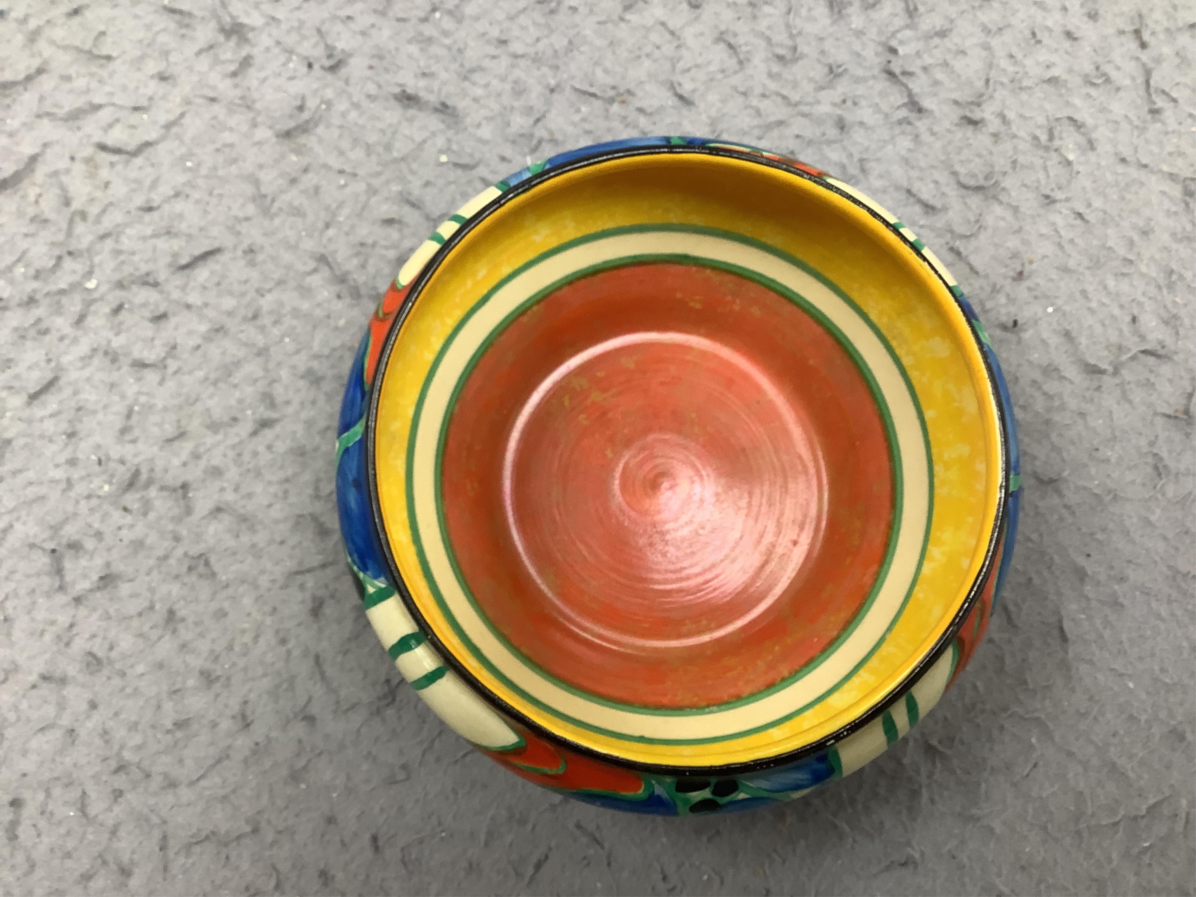 A small Clarice Cliff 'Fantasque' bowl, top rim 11cm diameter. Condition - minor chips to enamelling.